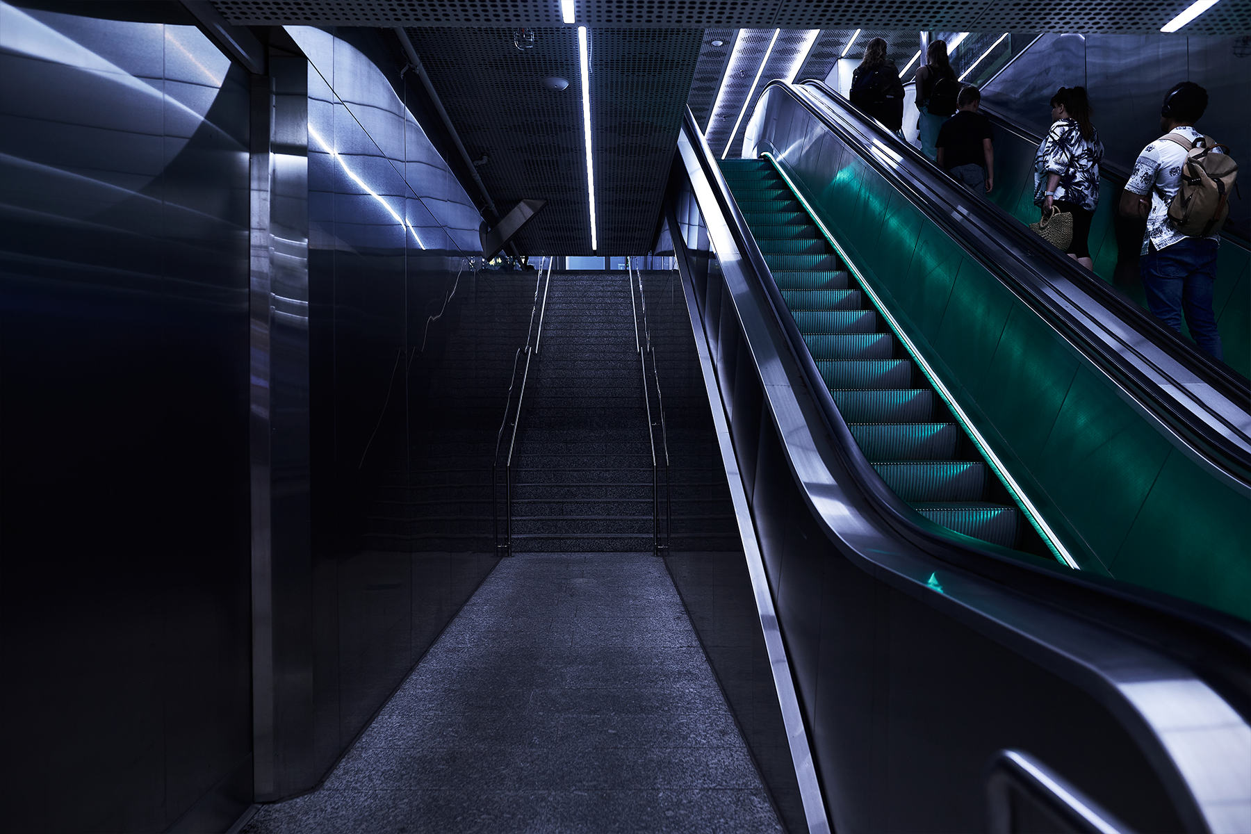  Illustration, mörk blå och grön bild av rulltrappor.